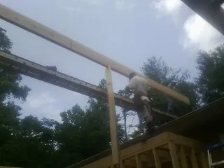 Carpenter setting a ridge beam over a new addition frame — Ice Dam Removal by Roofing Brothers in Dahlonega