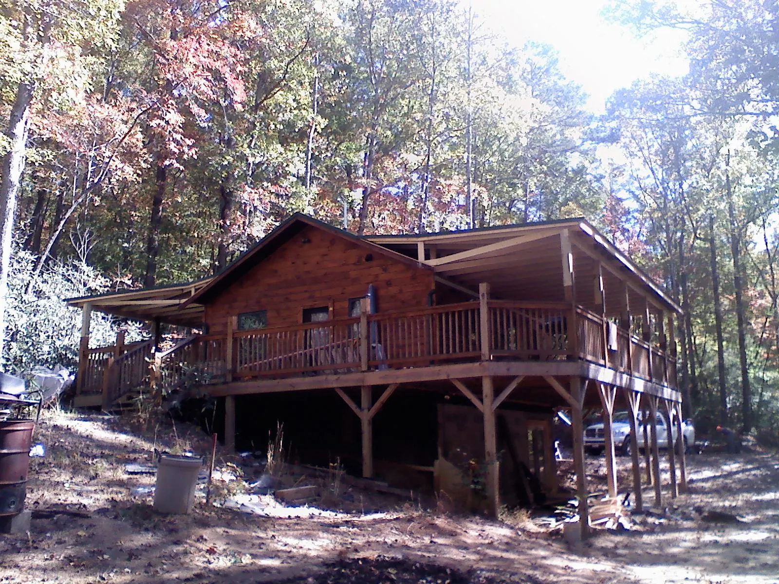 Log cabin with a wraparound porch and metal roof in the fall in Dahlonega